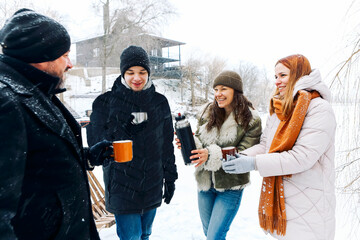 People at winter resort on winter holidays. Friends relaxing, drinking hot coffee.