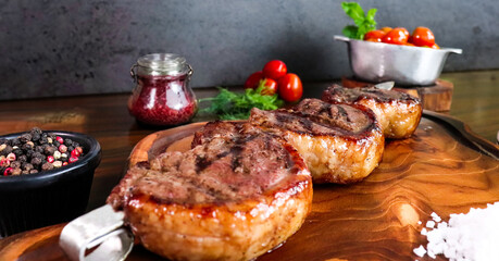 Close-up Exquisite cut of Picanha meat served on a wooden board accompanied by cherry tomatoes and...