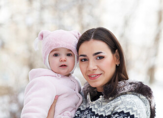 Obraz premium Young brunette mother with her daughter outdoors. Winter