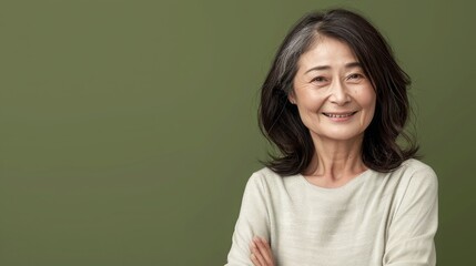 Fototapeta premium Happy Asian Woman. Portrait of Beautiful Older Mid Aged Mature Smiling Woman in Pink Clothes Isolated on Grey Background. Anti-aging Skin Care Face Beauty Product. Banner with Copy Space.