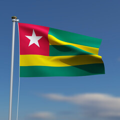 Togo Flag is waving in front of a blue sky with blurred clouds in the background
