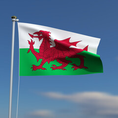 Wales Flag is waving in front of a blue sky with blurred clouds in the background