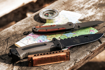 Camping kit for hiking in the wild, knife, map and compass with harmonica. Concept adventure and...