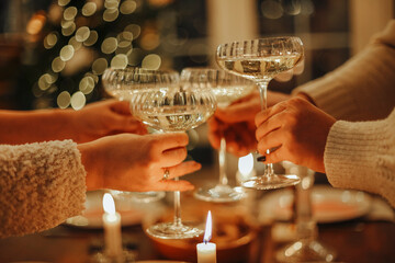 Happy friends clinking champagne glasses while celebrating New Years Eve or Christmas