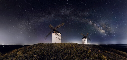 molinos de viento de castilla la mancha con el cielo lleno de estrellas y la via lactea