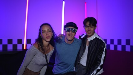 Diverse street dancer moving to city pop music at party with neon light while man wearing fancy glasses. Attractive hipster perform or practicing dancing together while looking at camera. Regalement.