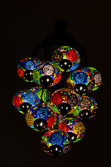 Traditional vintage of turkish lamps hanging on the ceiling at night. Exquisite colorful mosaic glass lamps, closeup, Turkey