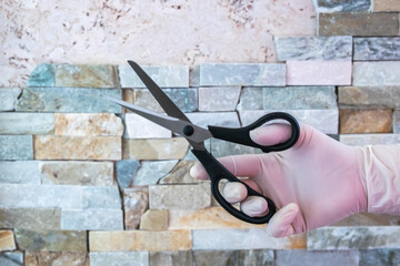 Steel shears in the hand with rubber glove.