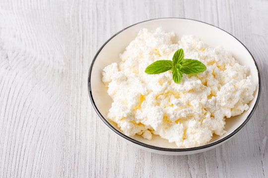 Cottage cheese in a plate on a white table, with copy space for text