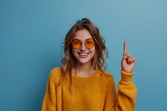 Portrait of young funny woman brown curls direct finger empty space shocked see secrets isolated on blue color background