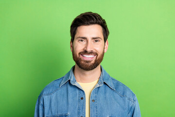 Photo of good mood handsome guy wear denim jacket smiling empty space isolated green color background