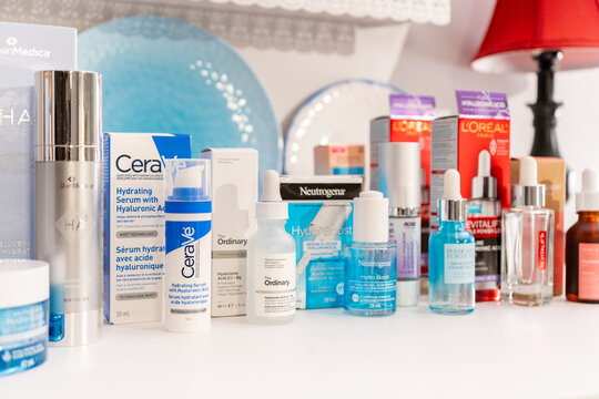 Surrey, B.C., Canada - 04.16.24 - Group of hyaluronic acid product brands for skin hydration displayed with their retail packaging in a bedroom setting, depicting a skin care routine concept.