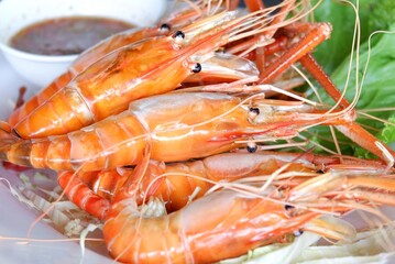  A dish full of grilled prawns with a spicy sauce on a food table