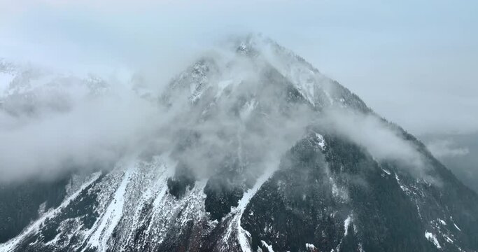 Spectacular view of the huge mount coated with fog. Some snow lies on the mountain in Mount Rainer National Park, Washington State, the USA.