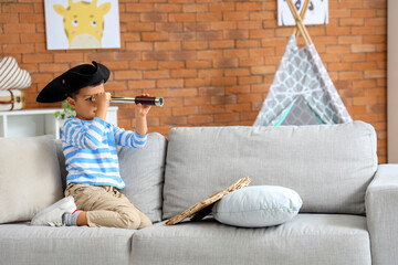 Cute little pirate with spyglass at home