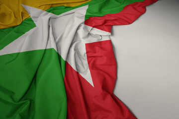 waving national flag of myanmar on a gray background.
