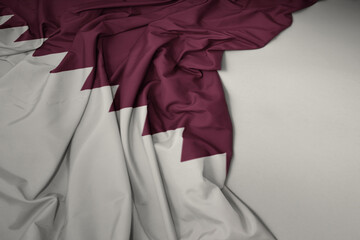 waving national flag of qatar on a gray background.