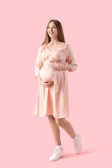 Young pregnant woman on pink background