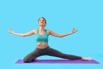 Young woman doing yoga on blue background
