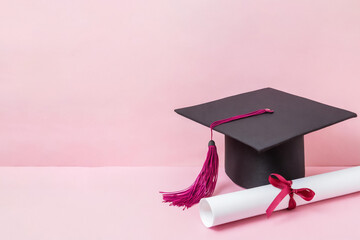 Graduationshut und Zeugnis vor rosa Hintergrund 