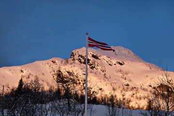 Norwegian flag with a snowy hill background