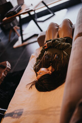 Casual indoor scene with a young woman lying down comfortably on a couch, depicting friendship and relaxation at home.