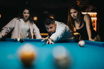 A group of friends enjoy a casual game of billiards at a local pool hall, showcasing leisure and companionship.
