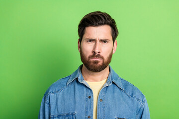 Photo of doubtful handsome guy wear denim jacket empty space isolated green color background