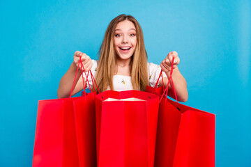 Photo of nice young girl hands hold shopping bags wear top isolated on blue color background