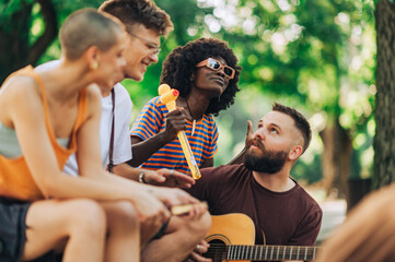 A young interracial musicians jamming in park.