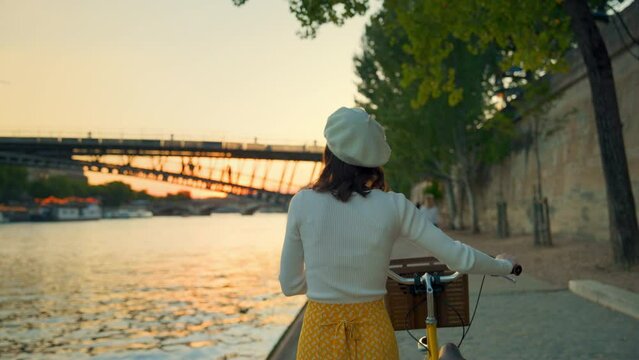 Woman with Bicycle Viewing Bridge at Sunset