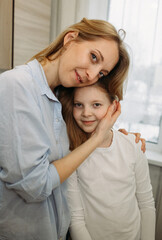 Fototapeta premium Woman Hugging Young Girl in Kitchen