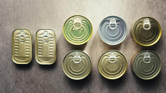  Metal Cans with Canned Food or Pate top view. Golden and silver cans with pull rings. Canned tourist food and fish or wet pet food, pate