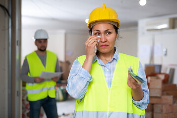 Asian woman builder crying because of low wages she got from her foreman.