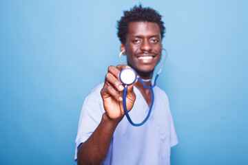 Close-up of African American healthcare specialist holding a stethoscope towards camera. Smiling...
