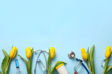 Stethoscope with yellow tulips, syringe and ampules for International Nurses Day on blue background