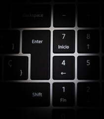 A close up of a keyboard with the enter key in the middle. The image is in black and white