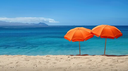 Fototapeta premium Two vibrant orange umbrellas provide shade on a sandy beach next to the ocean