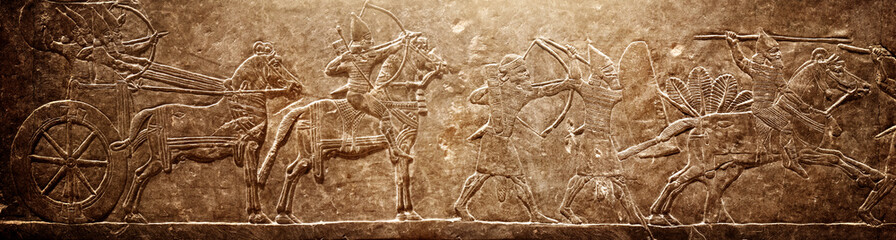 Assyrian relief on the wall. Ancient stone carving from the history of the Middle East. Historical background on the theme of civilisations of Assyria, Mesopotamia, Babylon, interfluve, Sumerian. - obrazy, fototapety, plakaty