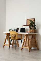 Interior of office with comfortable workplace, chair, houseplants and modern laptop