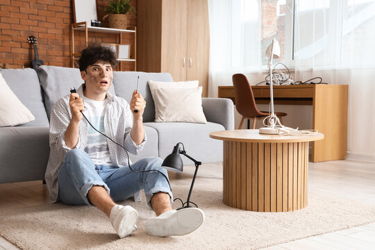 Electrocuted young man with burn face repairing lamp at home