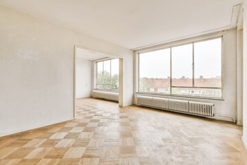 Spacious empty room with large windows and parquet floor