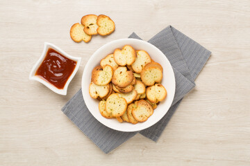 Spiced bruschette chips on wooden background, top view