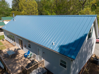 New steel metal light blue roof on a single family home featuring 5V style panels. 