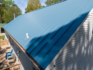 New steel metal light blue roof on a single family home featuring 5V style panels. 