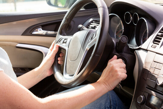 Driver's hands on steering wheel and gear shift