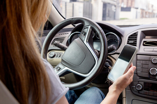 Woman using smartphone while sitting in a car