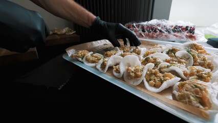 Caterer arranging shrimp appetizers on rice crackers for an event