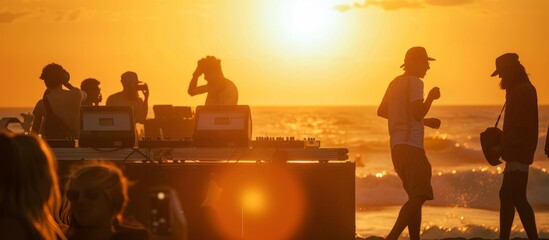 silhouettes at sunset of beach party with dj - 788794272