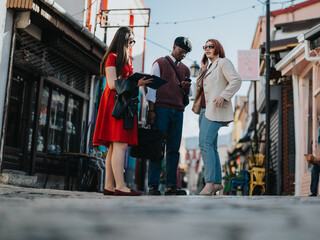 A group of young business workers engaged in a casual discussion on a busy urban street, giving off a relaxed professional vibe.